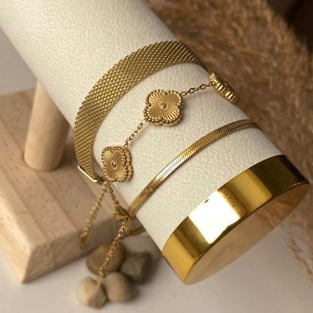 Gold bracelet on a white cylindrical stand